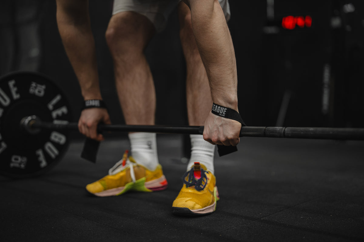 Lifting straps attached to a barbell